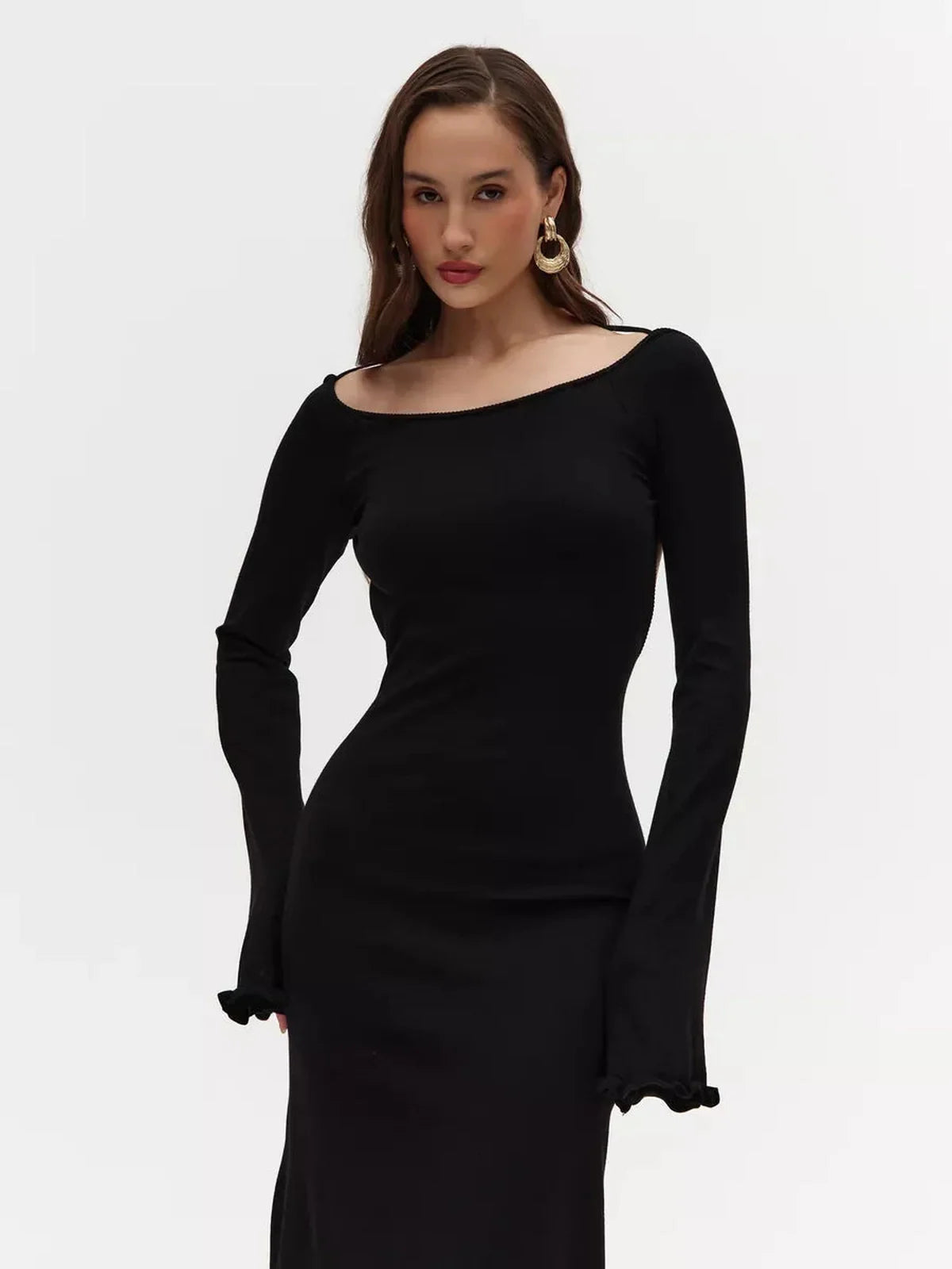 Model wearing the Noir Grace Midi Dress, a black long sleeve dress with an elegant open back and flared sleeves.