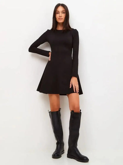 Sleek black mini dress with long sleeves and flared skirt, paired with knee-high black boots.