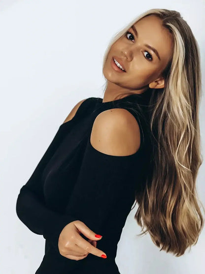 Elegant woman wearing a black Shadow Midi Dress featuring cutout shoulders, highlighting a chic and sophisticated style.