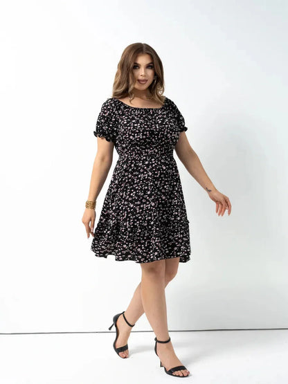 Model wearing a black floral dress with puff sleeves, perfect for summer weddings or casual outings.