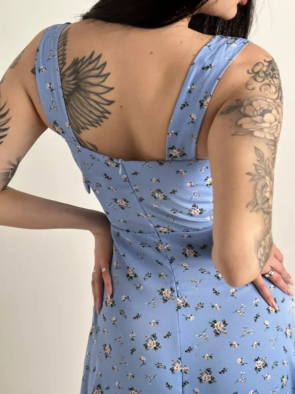 Back view of a floral midi dress with shoulder ties, showcasing a feminine design and elegant silhouette.