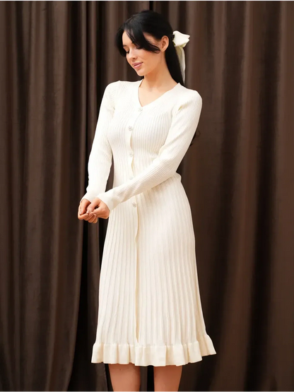 Woman wearing a Pearl Knit Midi Dress with ribbed texture, V-neckline, and long sleeves, perfect for weddings and formal events.