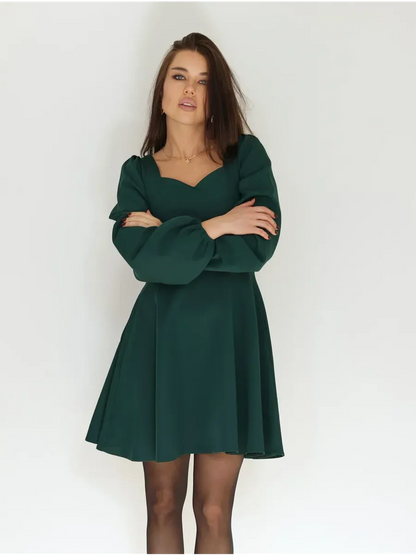 Emerald Grace mini dress features a sculpted bodice, puff sleeves, and flattering fit-and-flare silhouette.