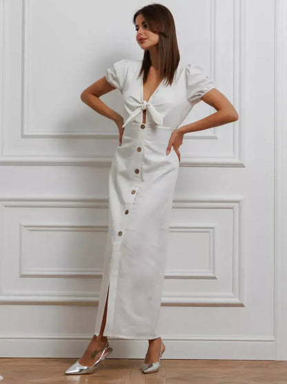 Elegant white maxi dress with tie-front, puff sleeves, and button-down skirt, perfect for weddings and summer events.