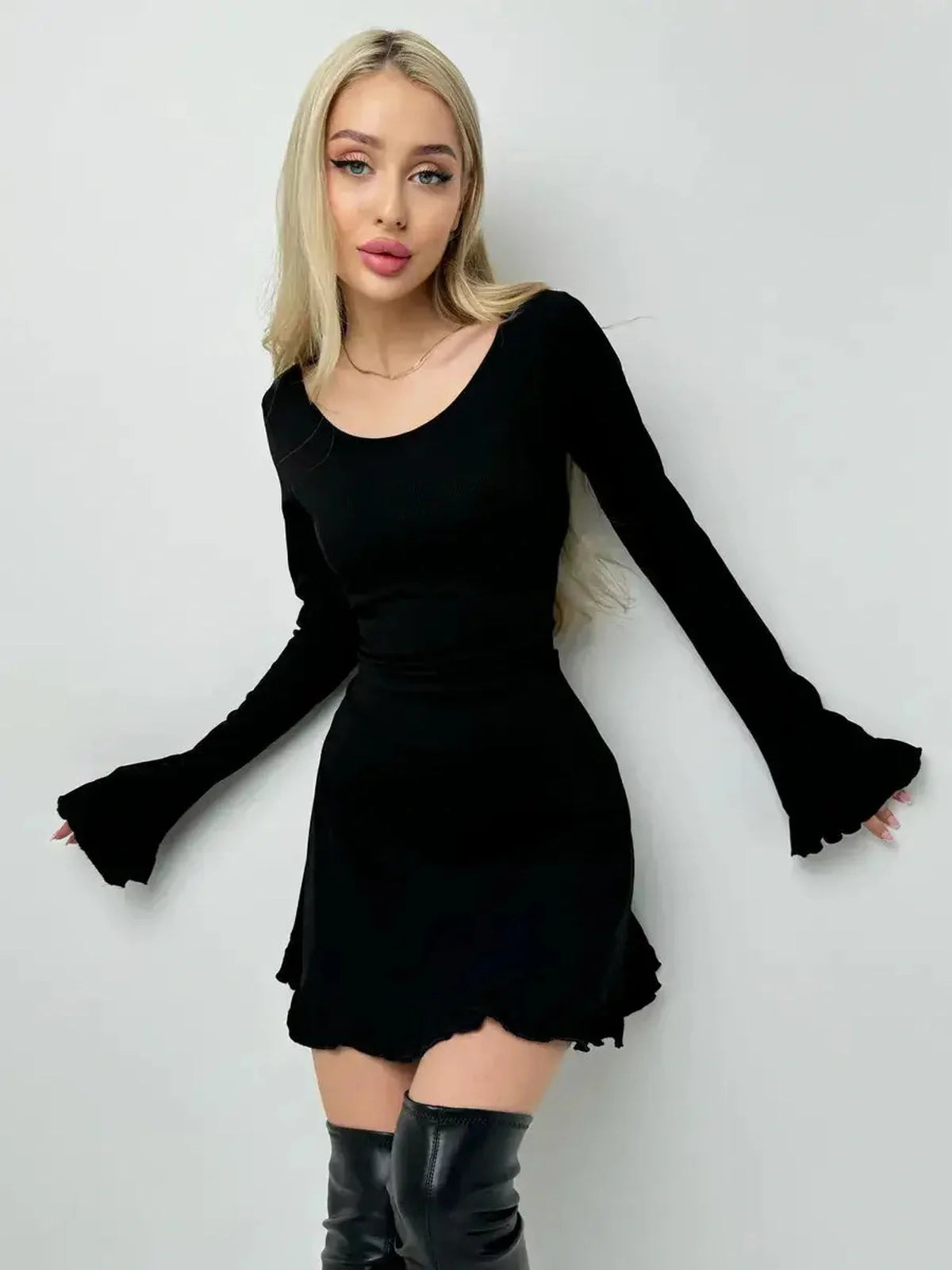 Chic black velvet lace mini dress featuring long flared sleeves and a playful silhouette, ideal for day-to-night looks.