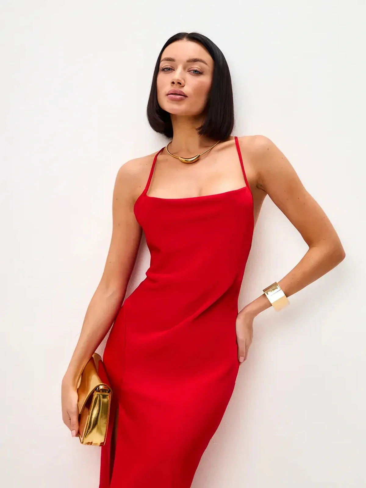 Model wearing a stunning red satin midi dress with a sleek open back and elegant accessories.