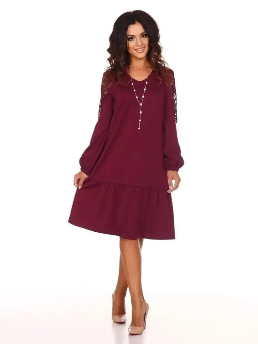 Model wearing a Lace Ruby mini dress with long lace sleeves and a drop-waist ruffle hem, perfect for weddings and casual events.