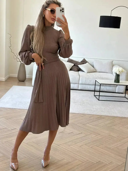 Model wearing the Plissé Charm Midi Dress in coffee hue, featuring ribbed texture and pleated skirt for an elegant look.