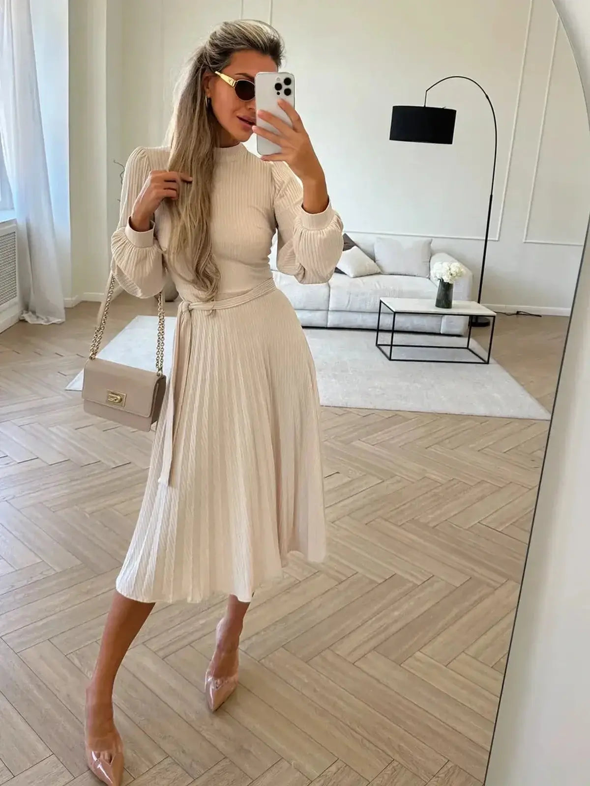 Model wearing an Ivory Whisper Midi Dress with a ribbed knit texture and pleated skirt, showcasing elegant style.