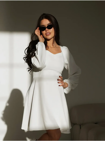 Stylish woman in a structured white dress with a sweetheart neckline, perfect for weddings and formal events.