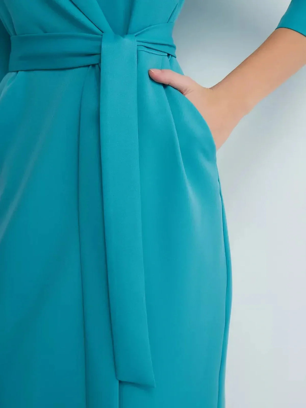 Close-up of the belted waist detail on the Elegance Wrap Midi Dress in turquoise, showcasing its tailored design.