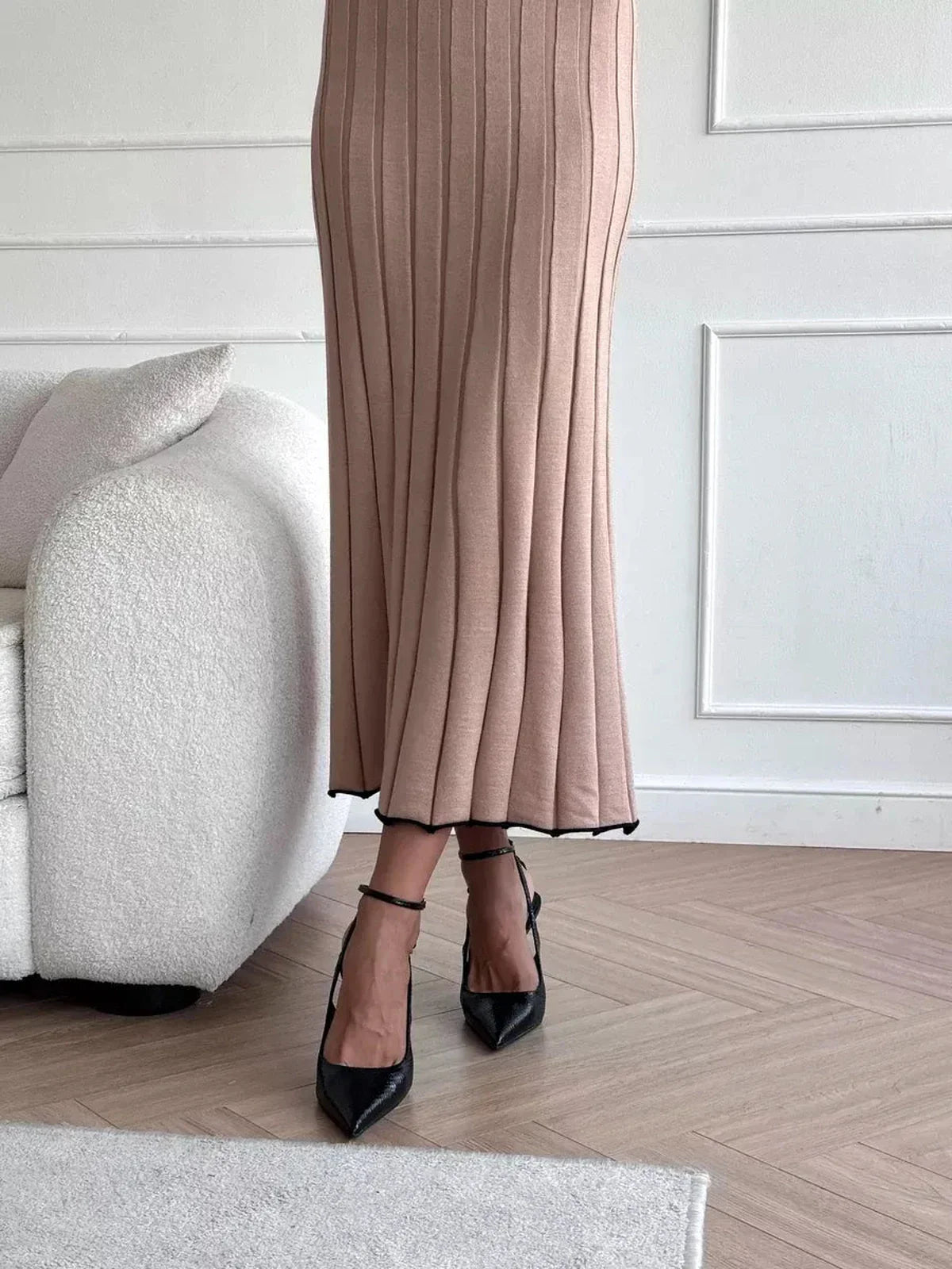 Close-up of a woman wearing a sandstone beige Sahara Curve Maxi Dress with a ribbed texture and black heels.