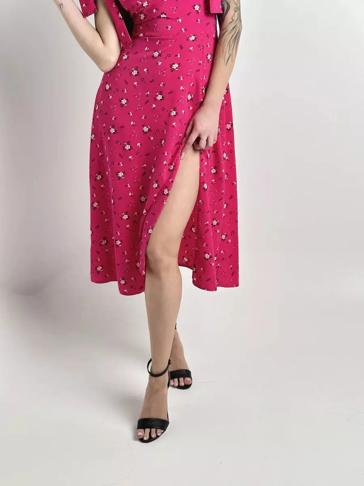 Model showcasing the Rosé Charm Midi Dress with floral print, featuring a thigh-high slit and chic black heels.