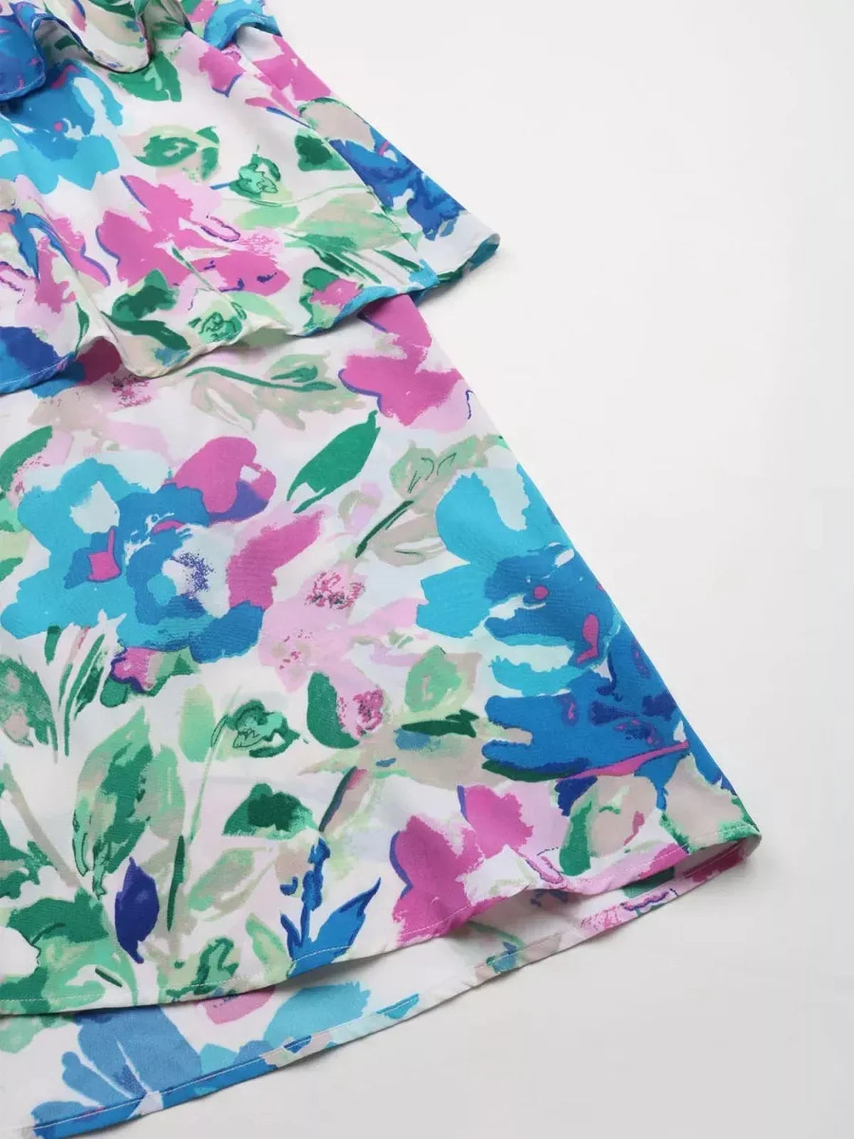 Close-up of the Petal Bloom Midi Dress featuring vibrant watercolor florals in pink, teal, and green hues.