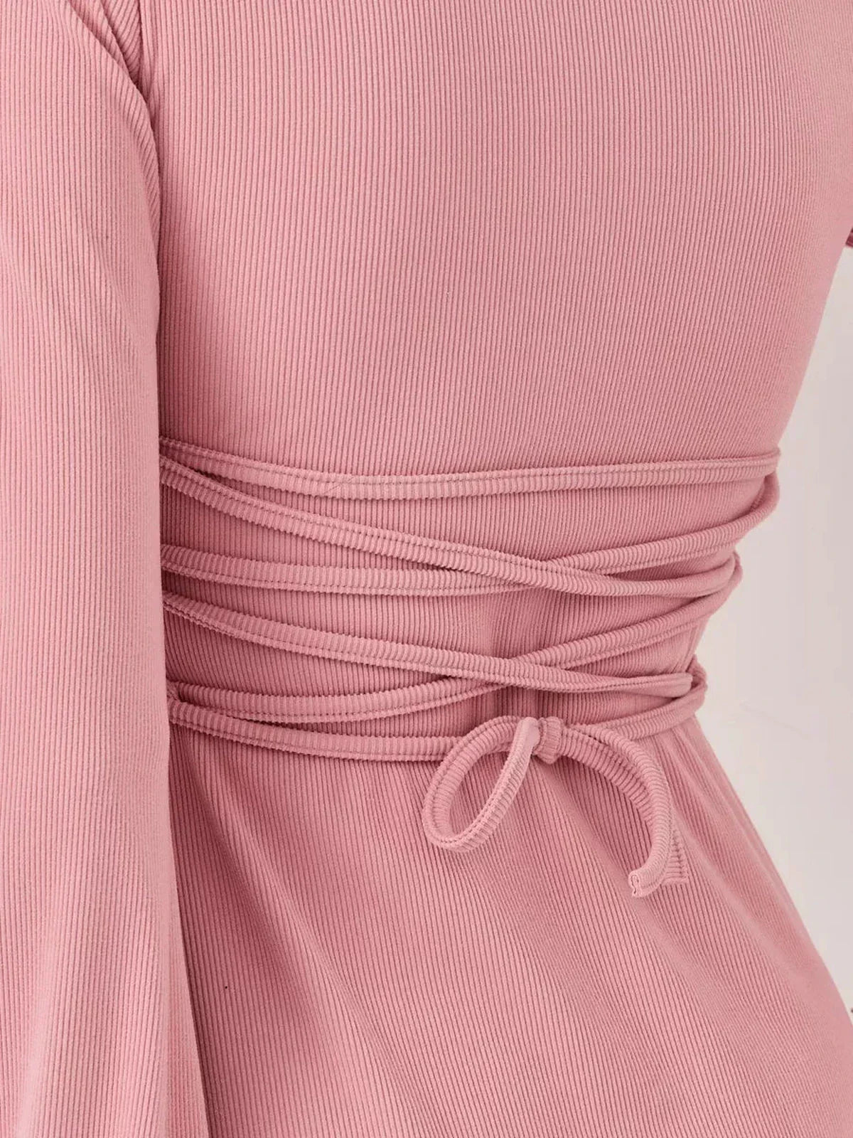 Detail of the back of the Blush Aura mini dress, showcasing the stylish tie design in soft pink fabric.