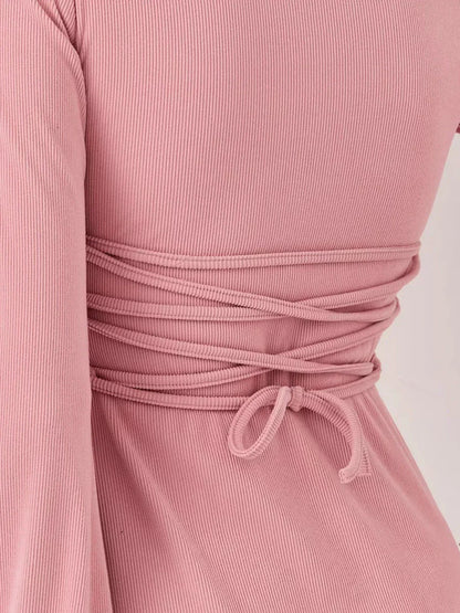 Detail of the back of the Blush Aura mini dress, showcasing the stylish tie design in soft pink fabric.