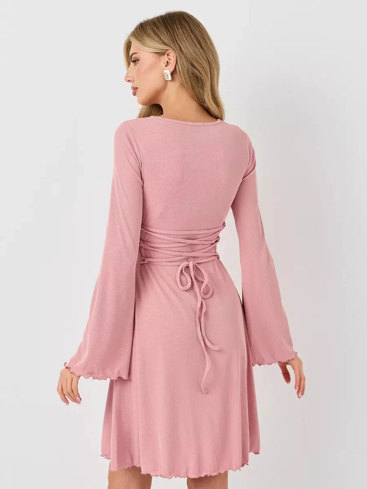 Back view of a pink Blush Whisper summer dress with flared sleeves and a fitted waist, ideal for wedding guest and casual outings.