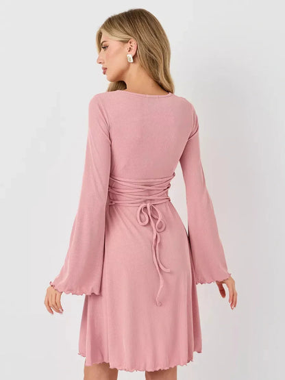Back view of a pink Blush Whisper summer dress with flared sleeves and a fitted waist, ideal for wedding guest and casual outings.