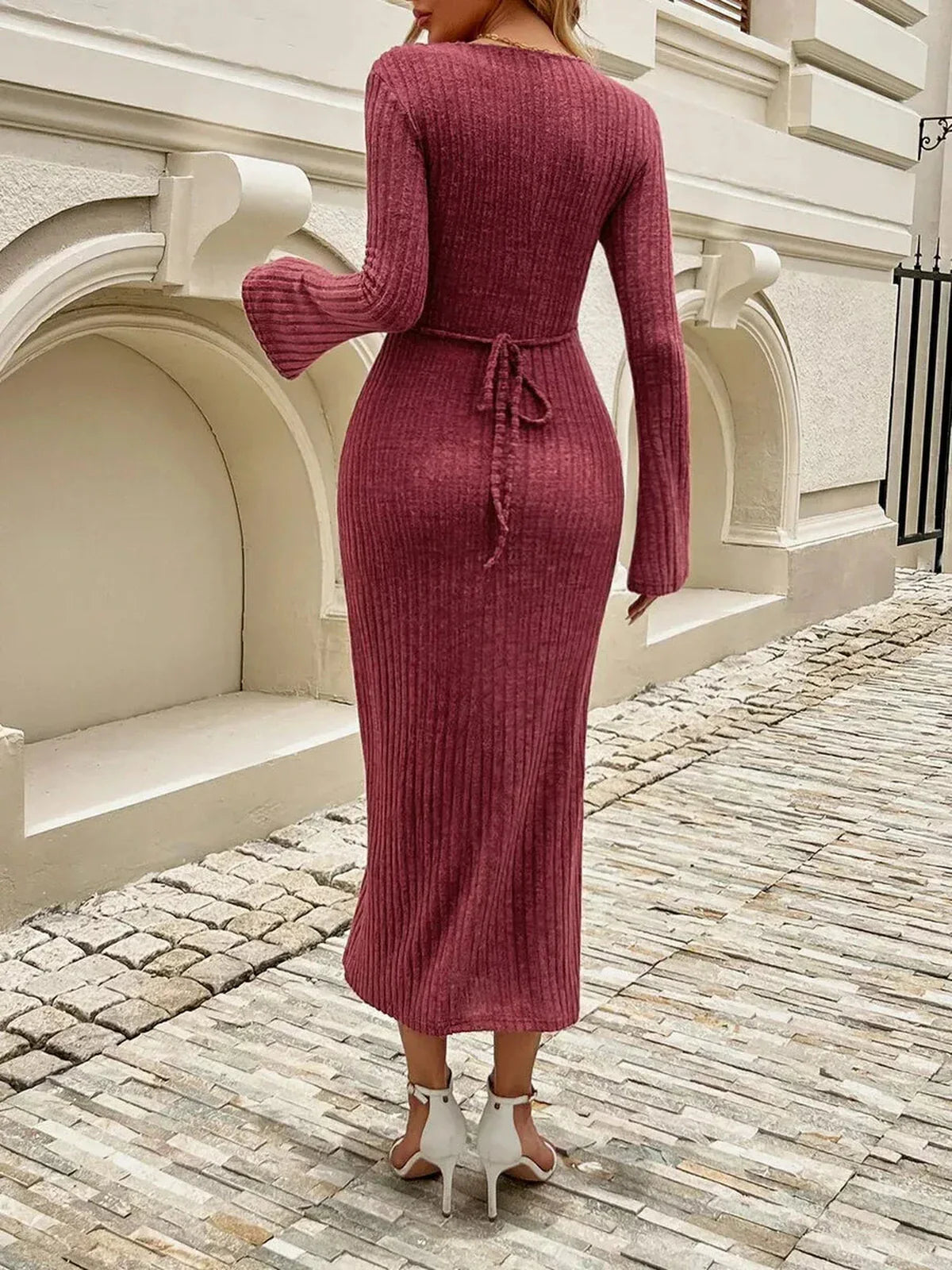 Back view of a woman in a chestnut ribbed midi dress with flared sleeves and a tie-back, ideal for elegant occasions.