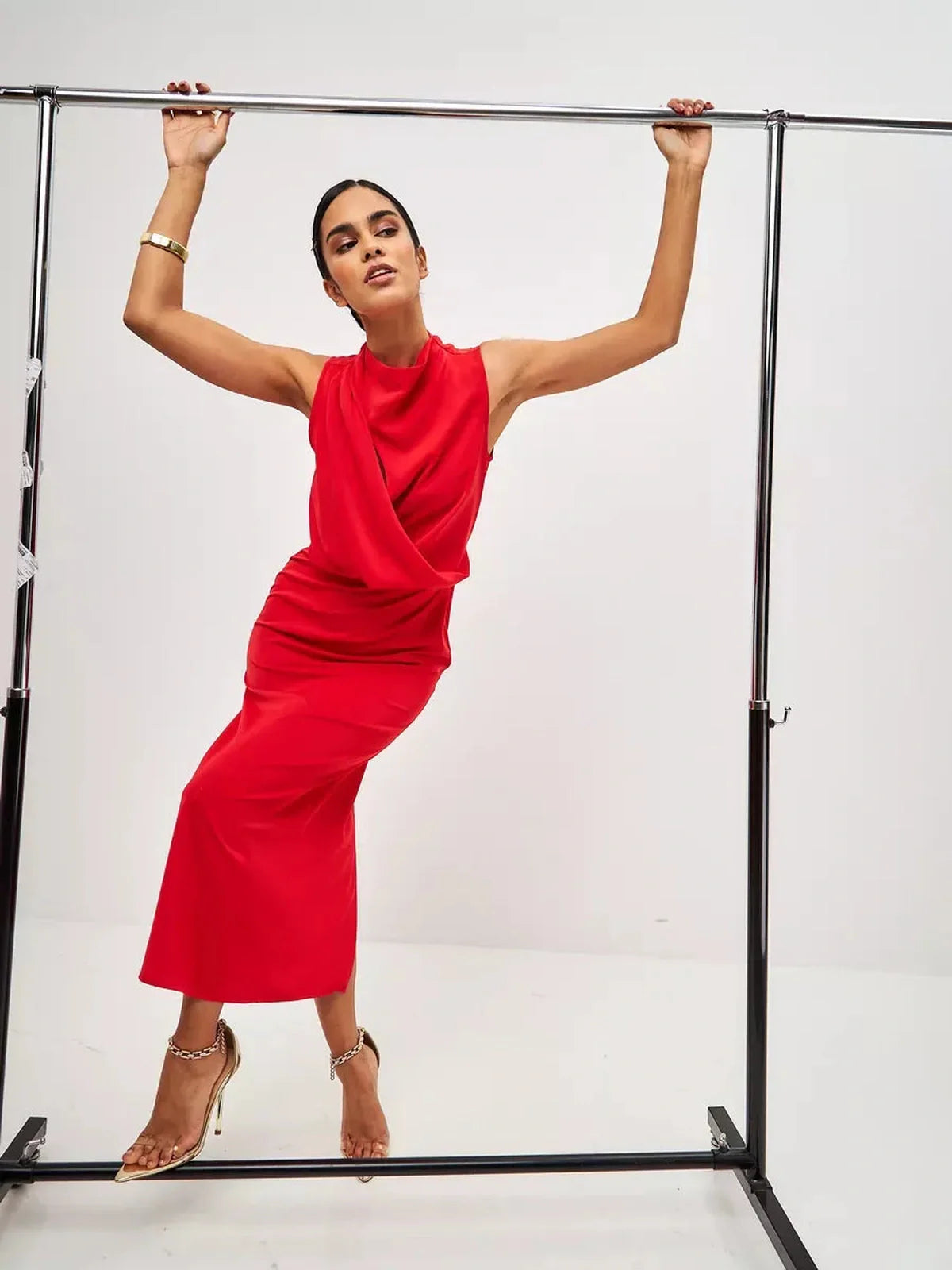 Model showcasing a red drape maxi dress with artful neckline and fluid silhouette, perfect for formal events and weddings.