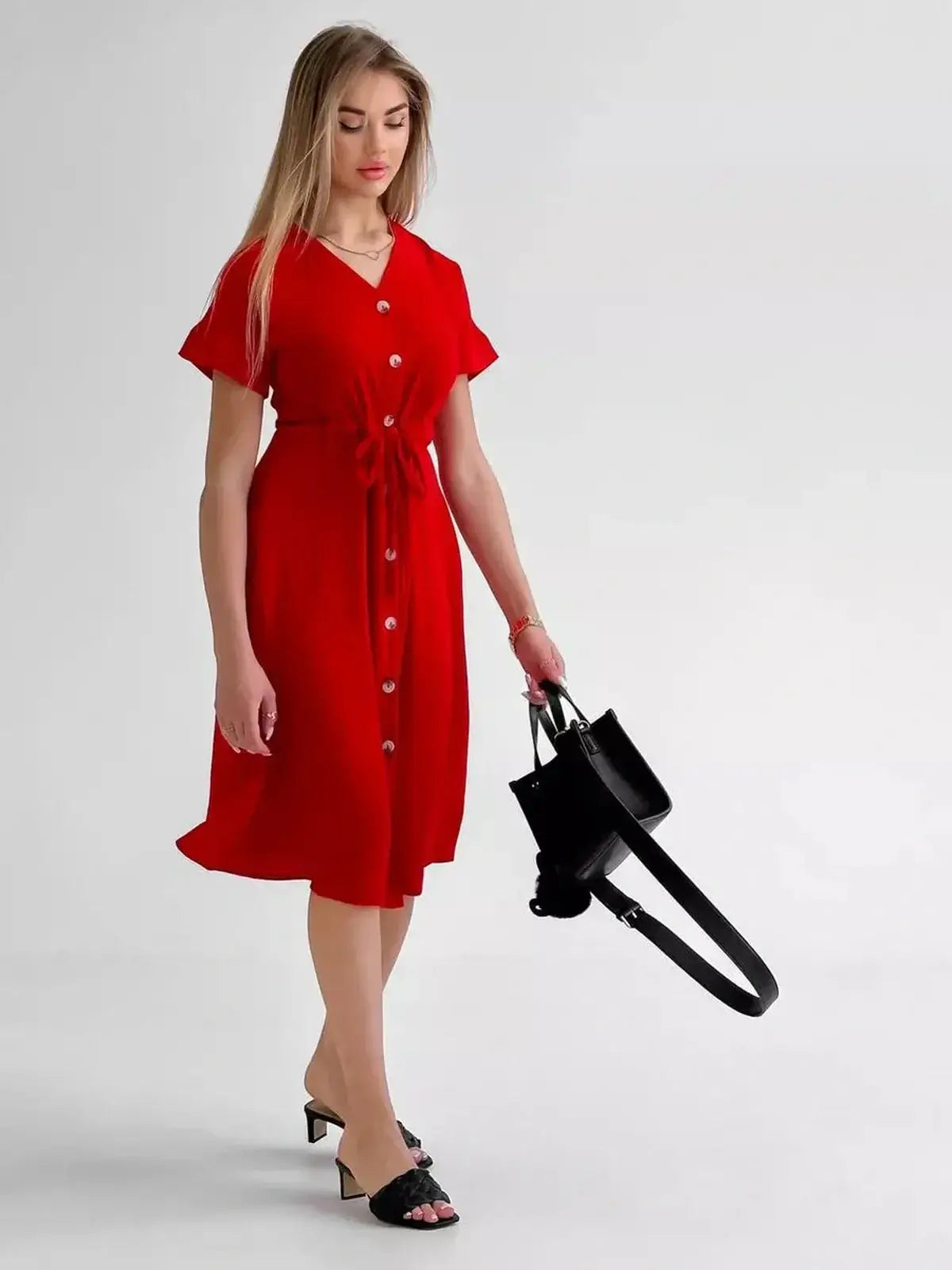 Woman in a crimson midi dress with button-front and waist tie, styled for a chic summer look.