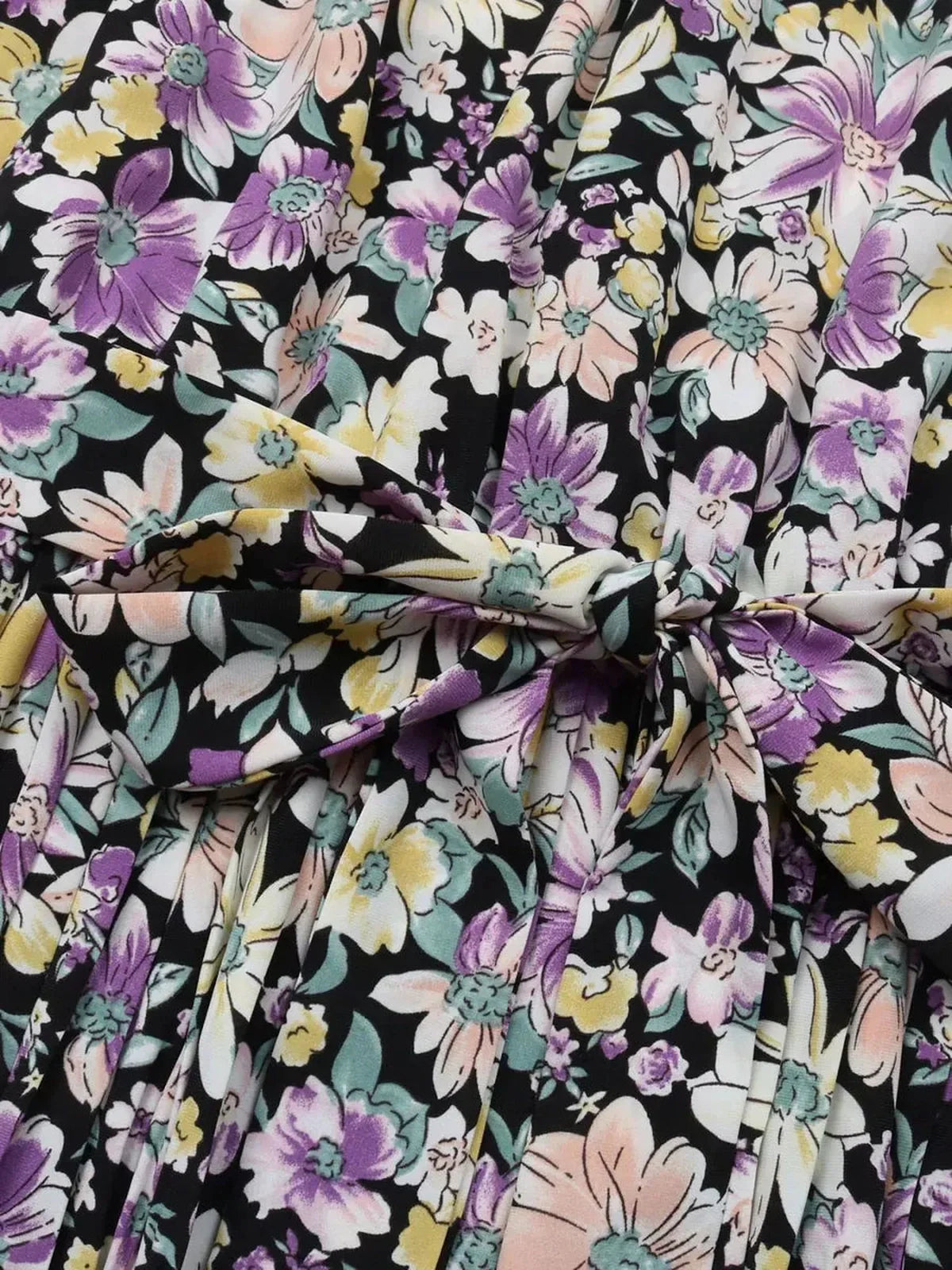 Close-up of the Botanic Bloom Midi Dress featuring a floral print with purple, yellow, and white flowers on a black background.