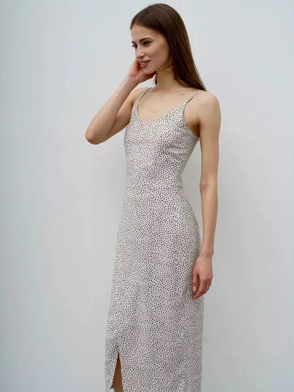 Side view of a woman in a polka dot midi dress, perfect for summer, weddings, or casual outings, showcasing its elegant design.