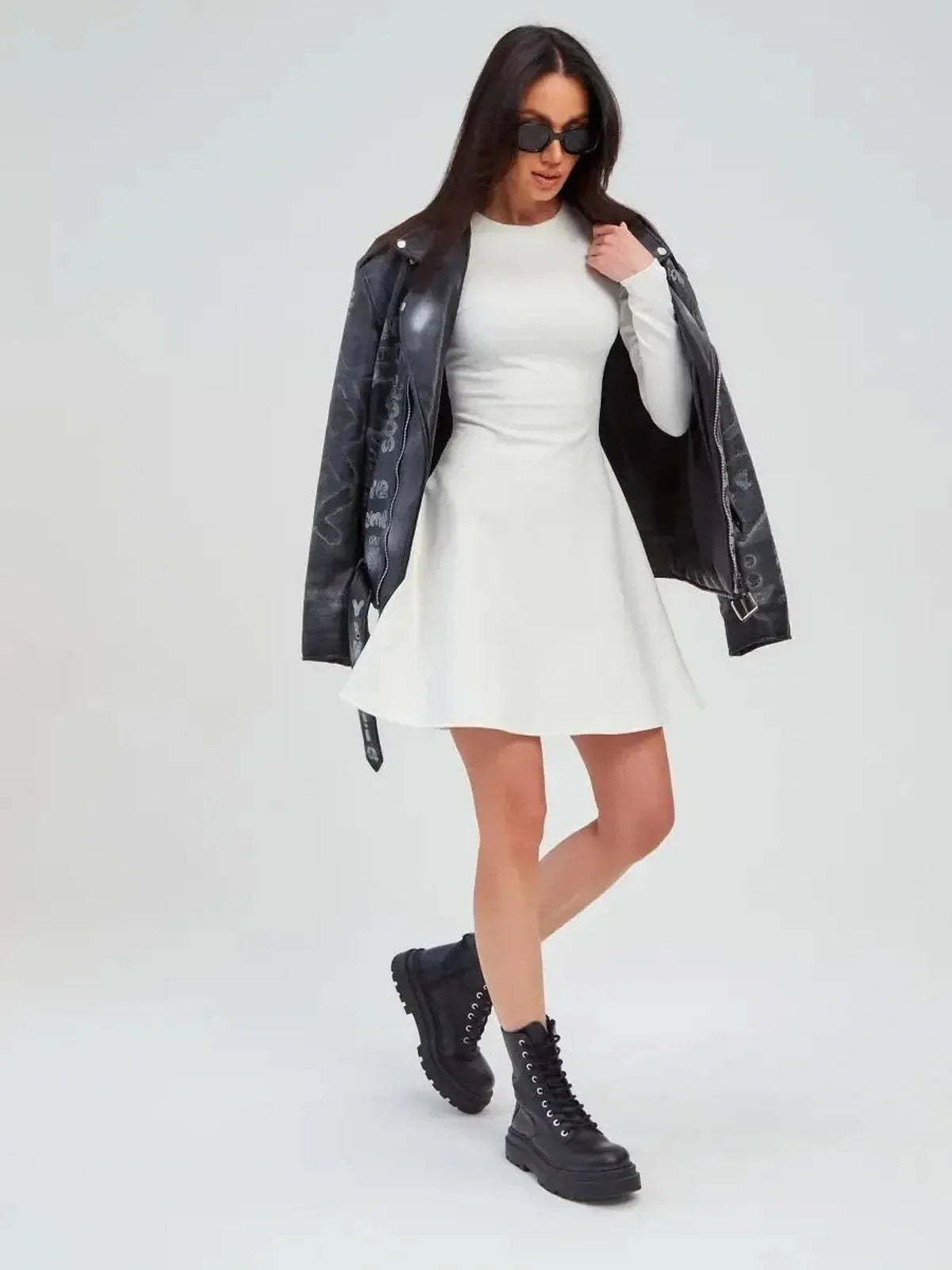 Model wearing the Ivory Sculpt Dress with a black leather jacket and chunky boots, showcasing a stylish summer dress.