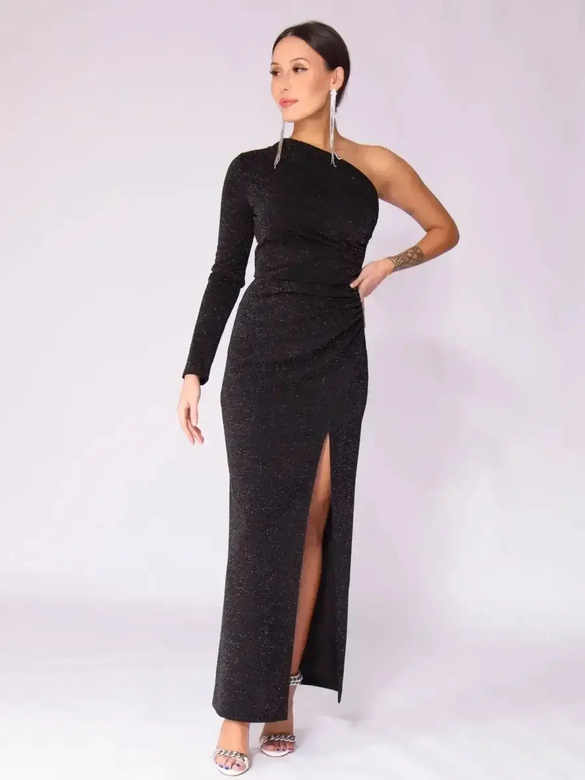 Luna Noir Maxi Dress featuring a black one-shoulder design, dramatic leg slit, and subtle sparkle for formal occasions.