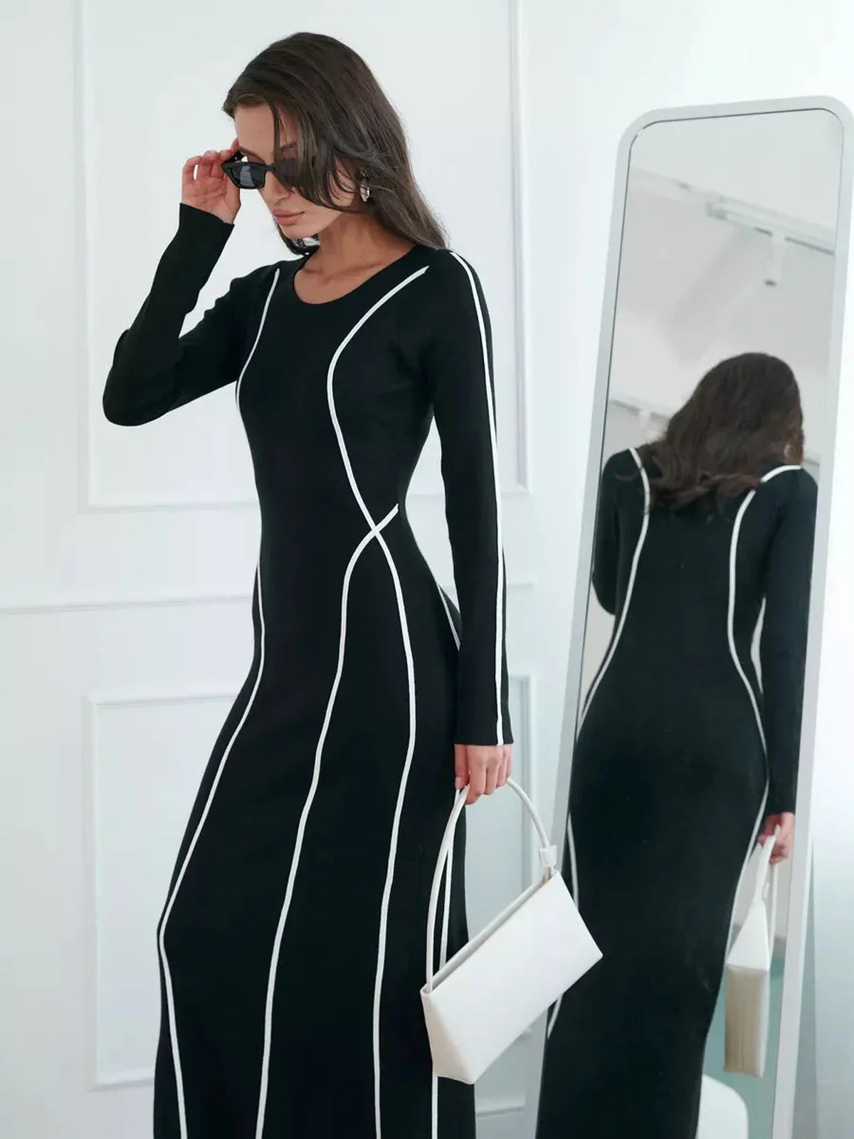Elegant black maxi dress with white piping, showcasing a sculpting silhouette, perfect for formal events and summer occasions.