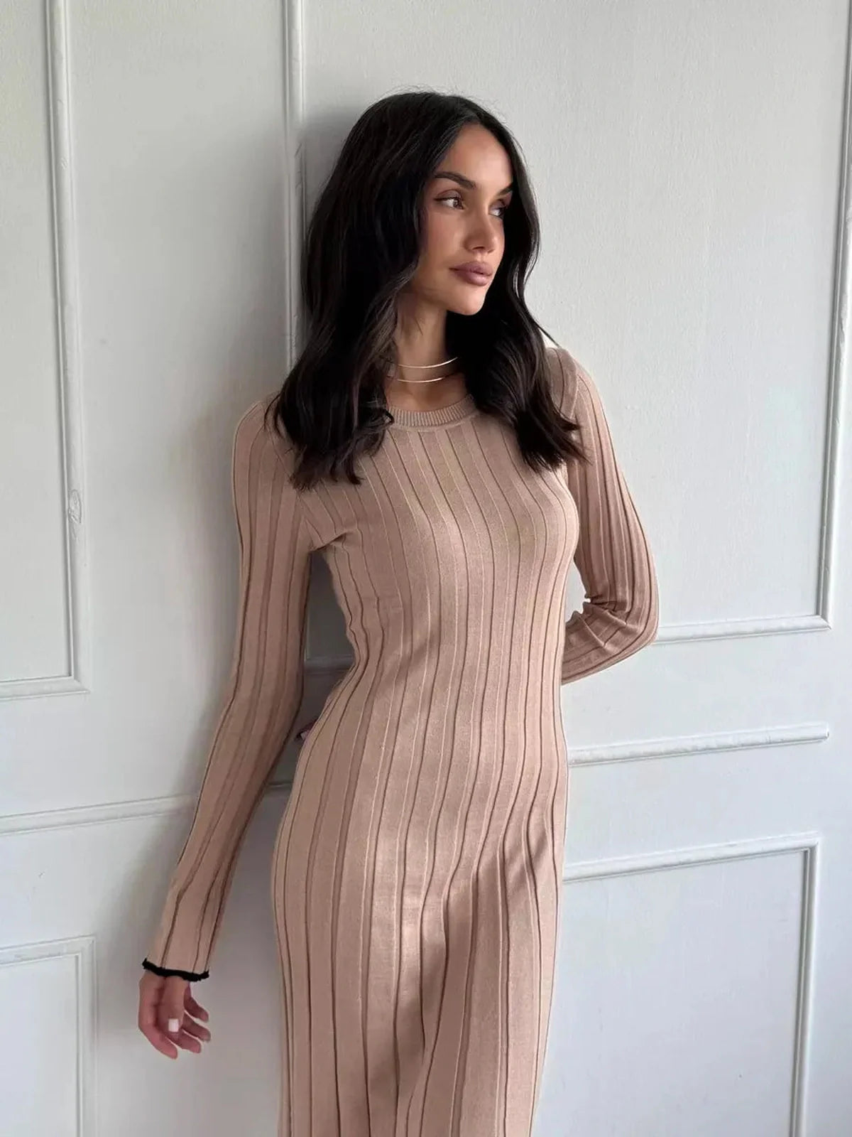 Model showcasing the Sahara Curve Maxi Dress in sandstone beige, featuring a soft ribbed texture and elegant full-length cut.