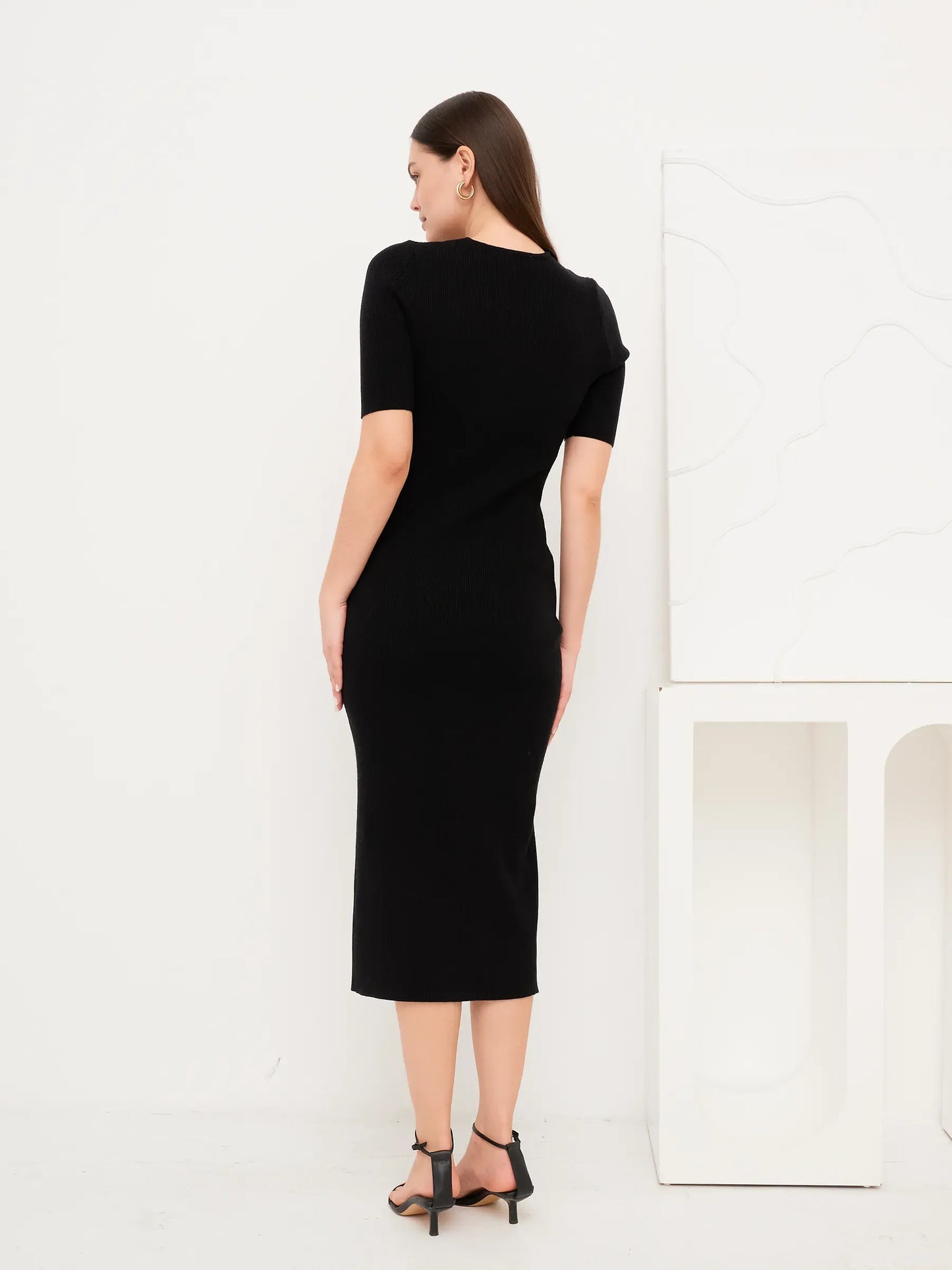 Back view of the Sculpted Grace Midi Dress, a fitted black rib knit dress with modern silhouette.