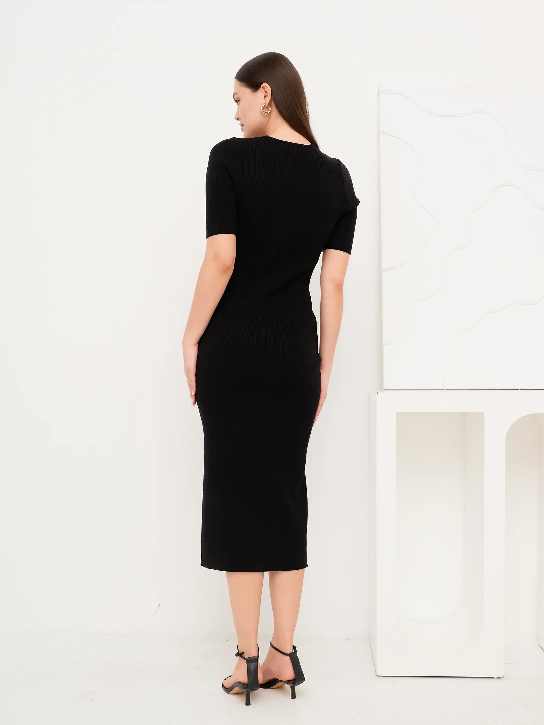 Back view of the Sculpted Grace Midi Dress, a fitted black rib knit dress with modern silhouette.