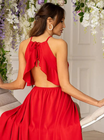 Woman wearing a vibrant red Radiance Midi Dress with a halter neck and ruffled open back, ideal for summer events.