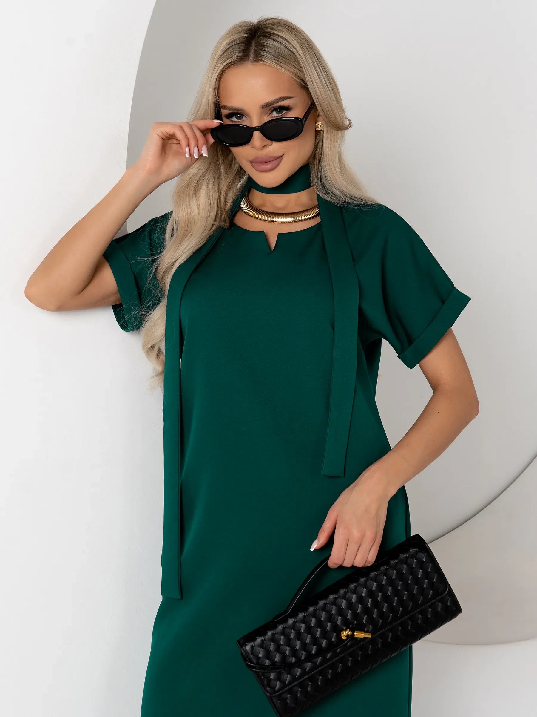 Emerald Mode green mini dress with notched neckline and cuffed sleeves, paired with fashionable accessories.