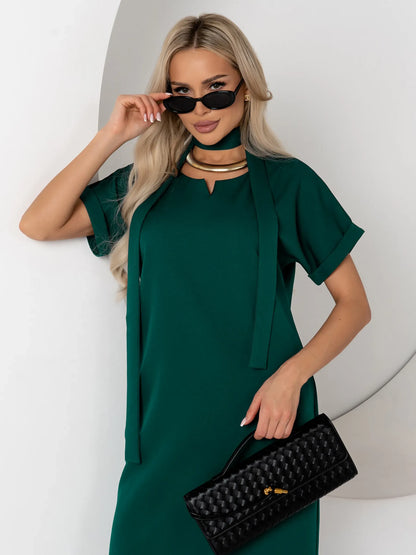 Emerald Mode green mini dress with notched neckline and cuffed sleeves, paired with fashionable accessories.