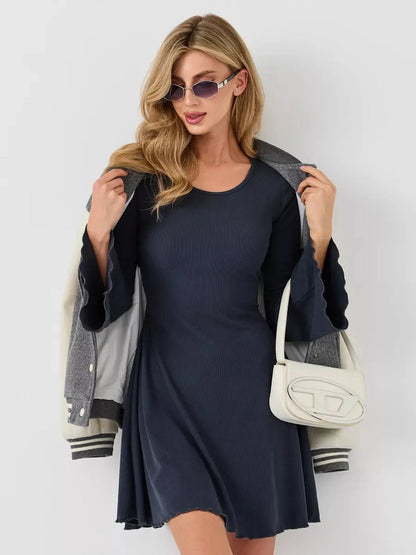 Stylish woman in a navy mini dress with flared sleeves, accessorized with sunglasses and a chic bag.