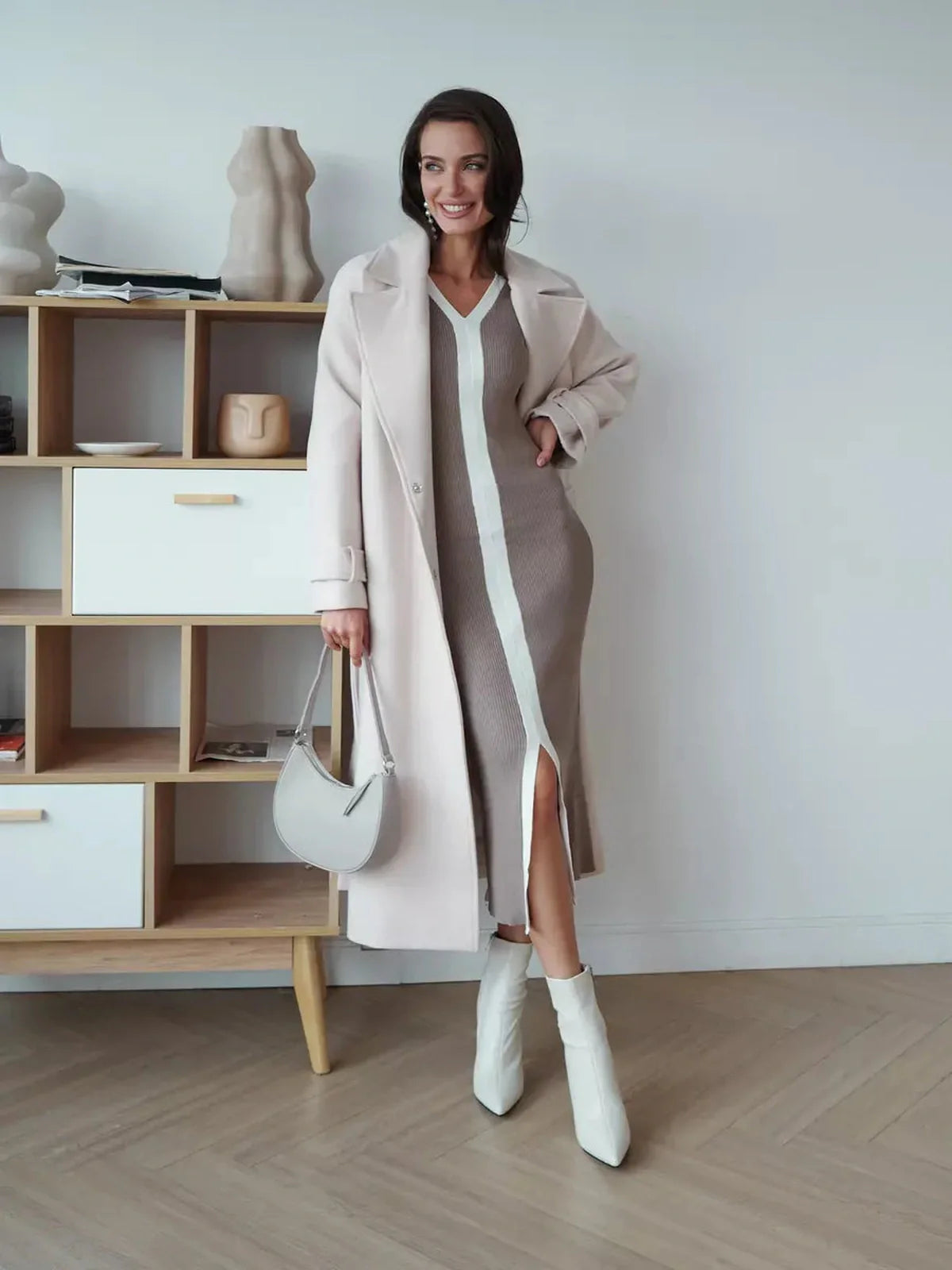 Stylish woman in a cappuccino midi dress with a front slit, paired with a light coat and heels, perfect for casual outings.