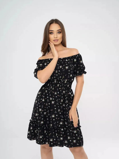 Model wearing a black floral mini dress with off-shoulder neckline, ideal for summer events and casual outings.