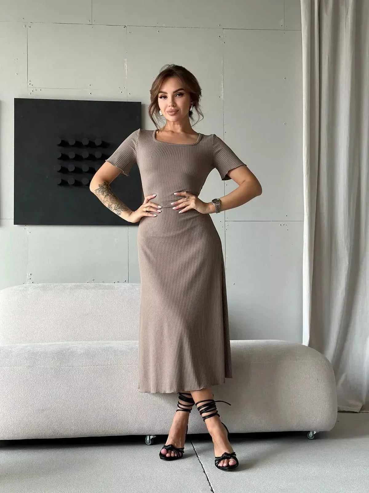 Contemporary woman posing in a ribbed contour midi dress with a fitted silhouette and stylish lace-up detailing.