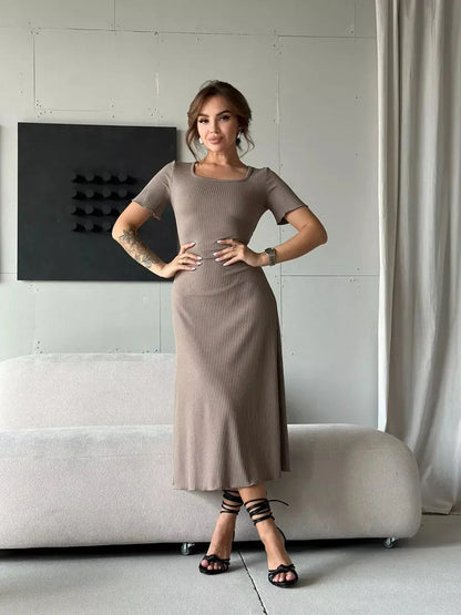 Contemporary woman posing in a ribbed contour midi dress with a fitted silhouette and stylish lace-up detailing.