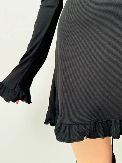 Close-up of Velvet Lace Mini black dress, showcasing ruffled hem and long sleeves, perfect for weddings or parties.