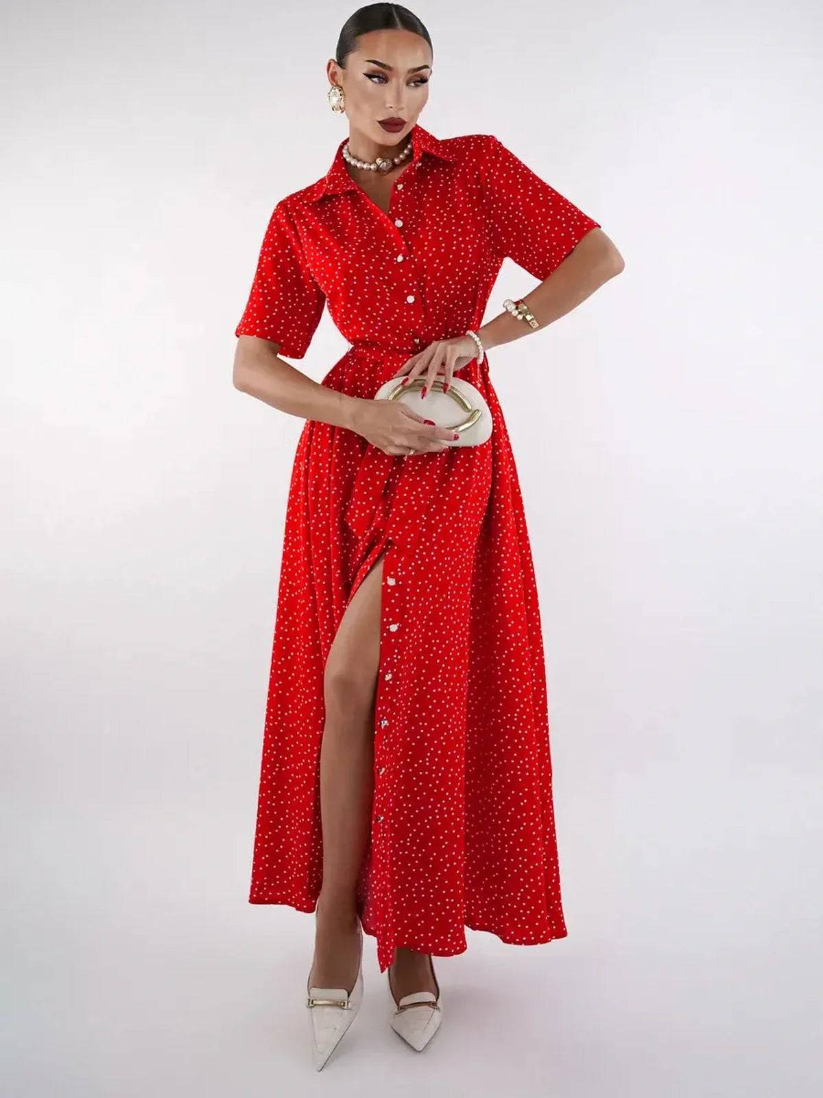 Model showcasing a vibrant red midi dress with polka dots and a high slit, perfect for summer occasions or cocktail events.