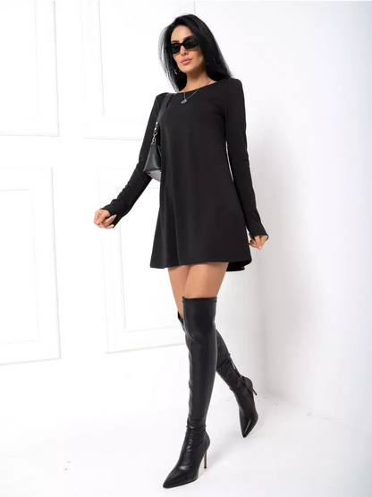 Stylish woman in a black mini dress with long sleeves and thigh-high boots, perfect for cocktail or casual occasions.