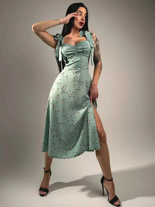 Flora Grace Midi Dress featuring romantic florals, statement bows, and a thigh-high slit for elegant spring events.