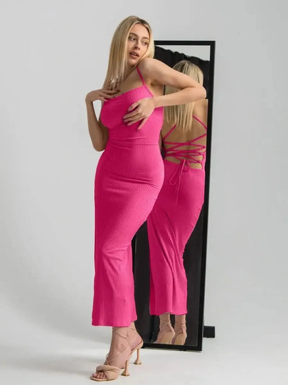 Model wearing a pink Lush Lace Midi Dress with a lace-up back detail, showcasing a sleek silhouette in front of a mirror.