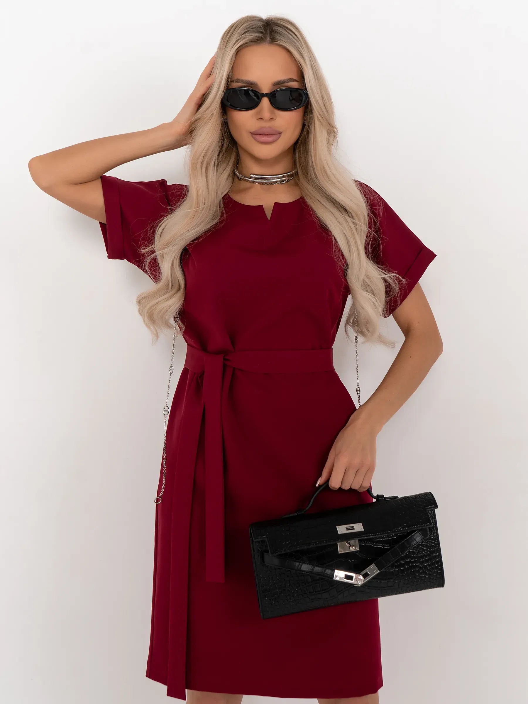 Model showcasing the Crimson Code mini dress, a wine-red, structured piece with a sleek silhouette and detachable belt.