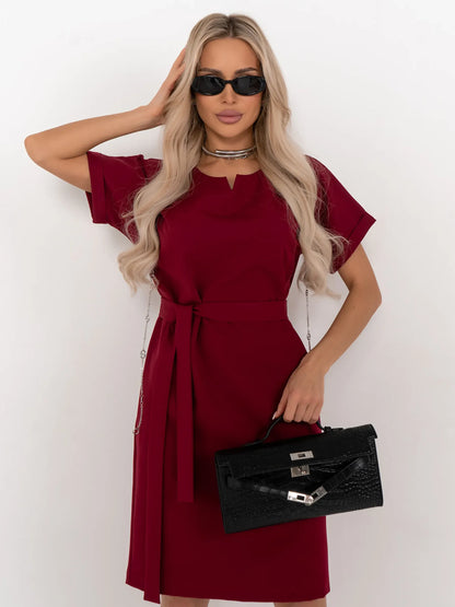 Model showcasing the Crimson Code mini dress, a wine-red, structured piece with a sleek silhouette and detachable belt.