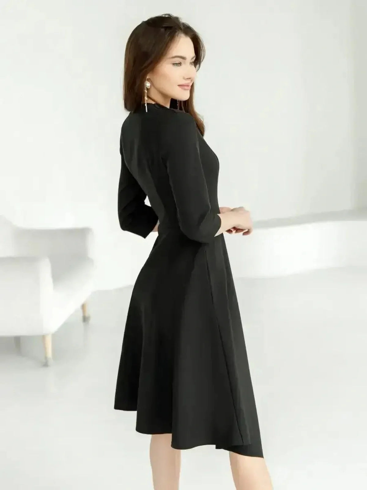 Elegant black midi dress with a flowing skirt and three-quarter sleeves, perfect for formal occasions and weddings.