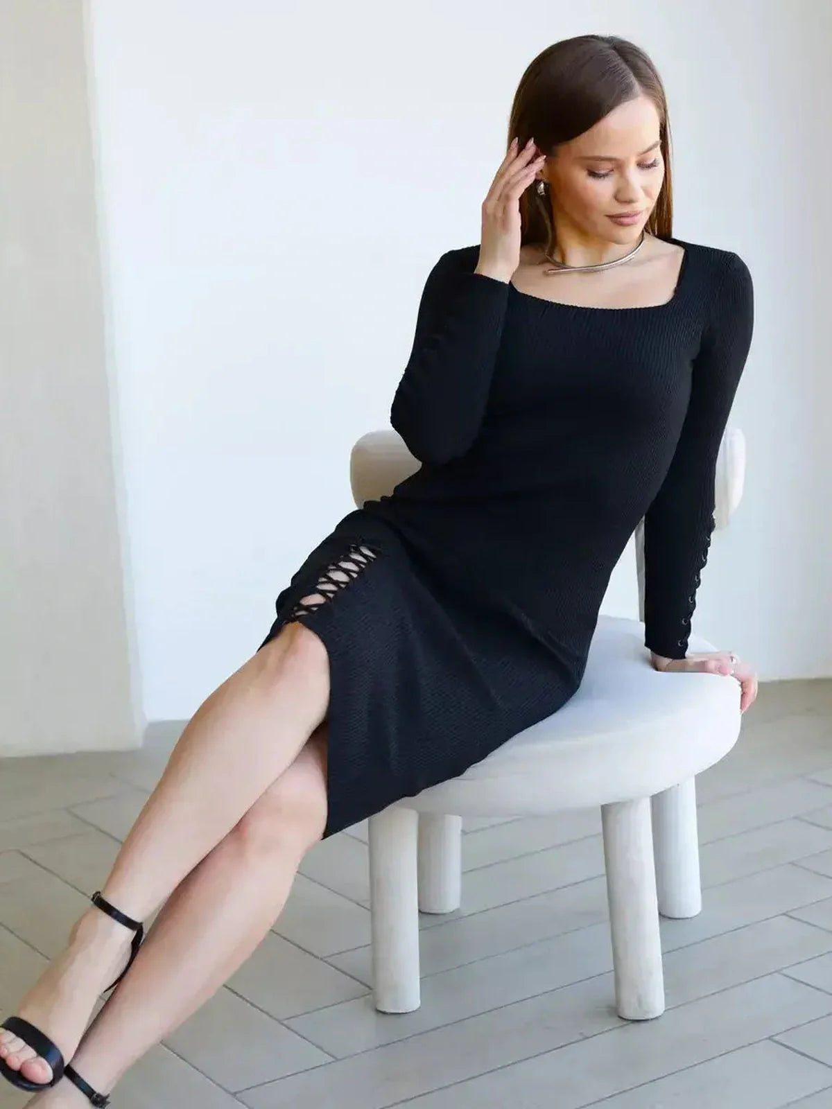 Model wearing Laced Allure Midi Dress, a body-hugging black midi dress with lace-up accents, showcasing a chic, elegant style.